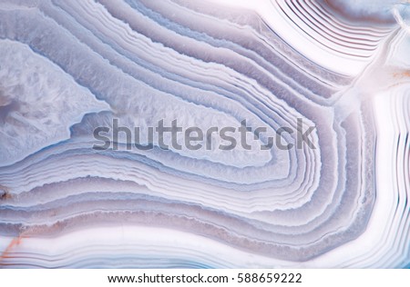 Detail of a translucent slice of natural stone agate. Natural concentric patterns and textures of minerals for background. Natural stone agate surfaces, backgrounds and wallpapers.