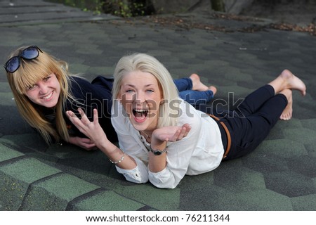 Two girlfriends laughing on the roof