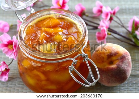 Nectarine peach apricot jam in a jar on the table.