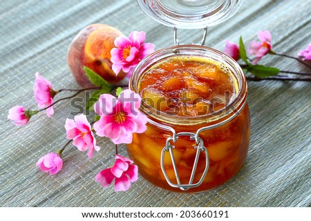 Nectarine peach apricot jam in a jar on the table.