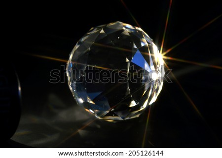 Crystal ball on black background with rays.