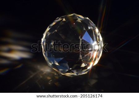 Crystal ball on black background with rays.