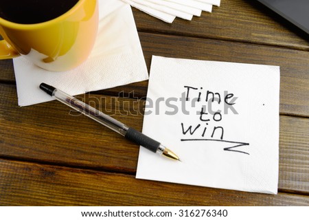 Time to win think positive -  handwriting on a napkin with a cup of coffee