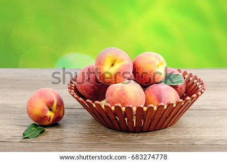 juicy peaches on wooden basket and table in garden