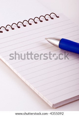 pen over lined note pad with spiral binding