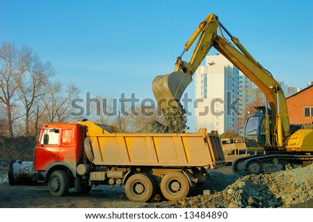 excavator and truck at building site