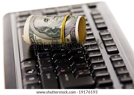 Money roll over computer keyboard