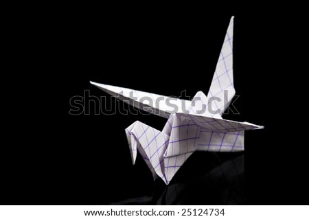 An origami paper crane over black