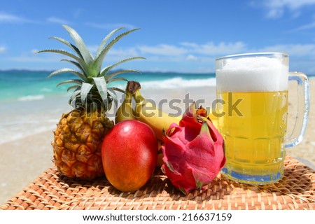 Tropical fruits with beer on the sandy beach