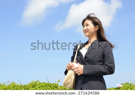 Smiling young woman holding a shoulder bag