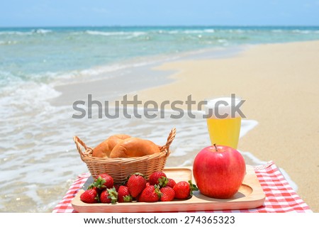 Fruits with a glass of beer on the beach