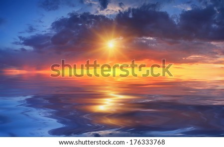 Beautiful sunset over sea with reflection in water, majestic clouds in the sky
