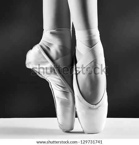 A photo of ballerina\'s pointes on black background