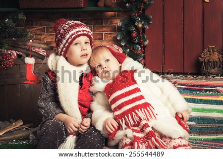 Photo of two beautiful children playing in a Christmas garden