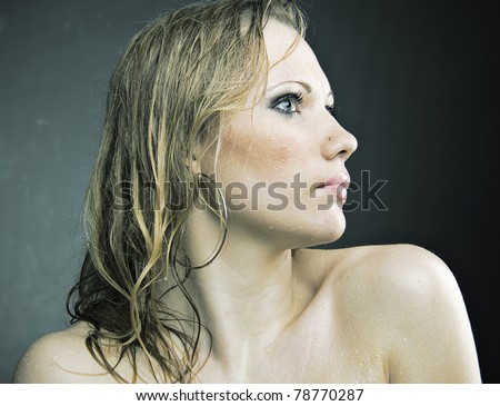 Thoracic portrait of pretty wet and nude girl staying forward to camera, looking away