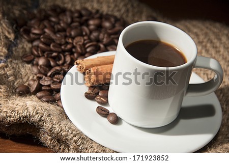 Coffee time: a coffee cup with coffee beans and cinnamon