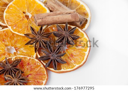 Sliced dried orange with cinnamon sticks and  anise stars on white background