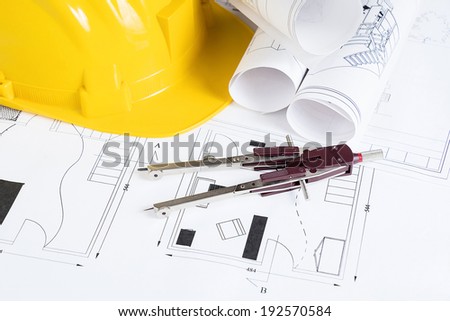 Engineer workplace with blueprints, compass  and safety helmet