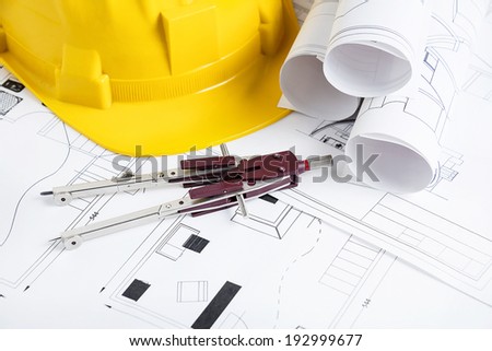 Engineer workplace with blueprints, compass  and safety helmet