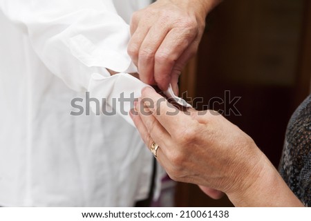 Mom helps groom wear cufflinks