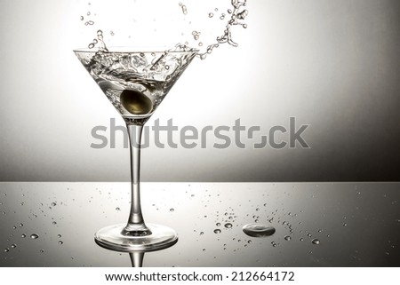 Olive splashing on a martini cocktail