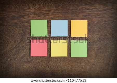Six colorful sticky notes on wooden background