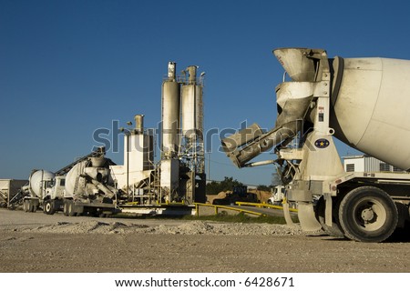 Cement mixer truck with plant in background