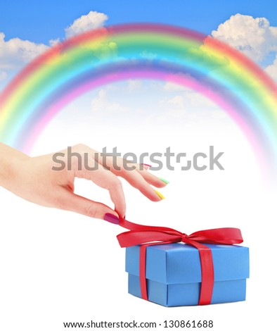 Hand opens gift rainbow blue summer sky