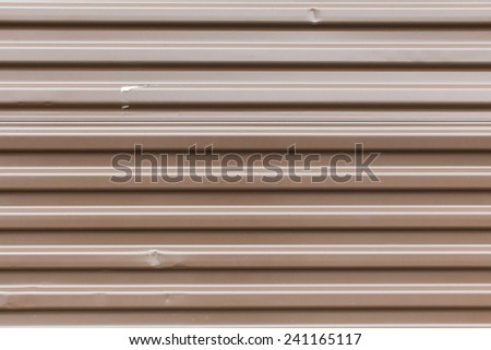 Brown aluminum metal with horizontal stripes, dents, and a patch