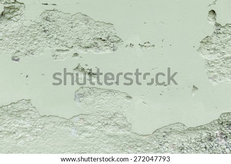 Concrete wall floor background with chips, crack, paint speckles, pale green paint, texture