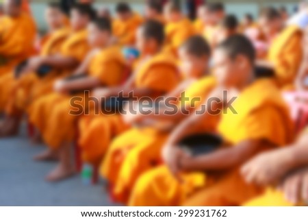 biurred buddhist monks waiting for alms