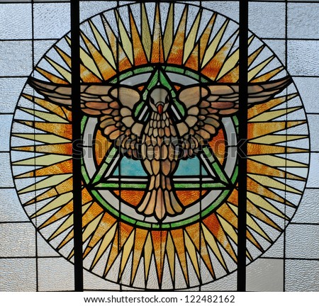 image: stock-photo-stained-glass-window-depicting-the-holy-spirit-as-a-dove-and-trinity-as-triangle-122482162