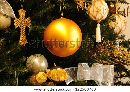 Gold balls and gold cross ornaments on Christmas tree
