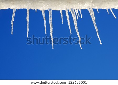 Winter border; icicles against beautiful blue sky