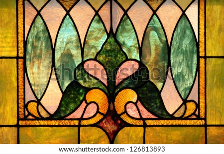 Stained glass window with stylized fleur-fe-lis flower pattern and oval shapes