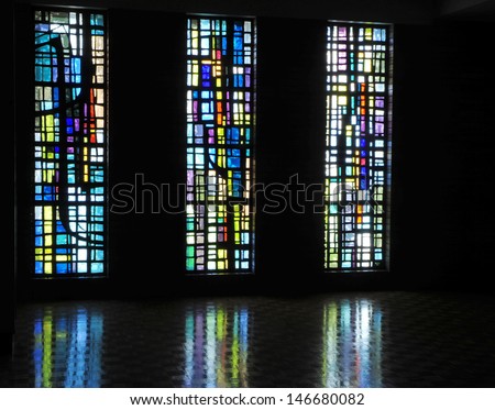 Three modern abstract stained glass windows made of colorful chipped glass slabs