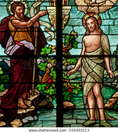 Stained glass window depicting Bible story of Saint John the Baptist baptizing Jesus in the Jordan River