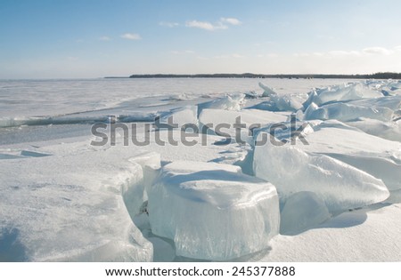 Winter scene: Blocks of ice along shore of frozen lake