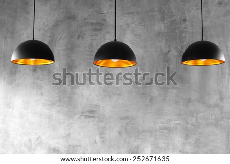 Blank cement wall with three lamps above