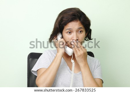 woman talking telephone with hand close mouth