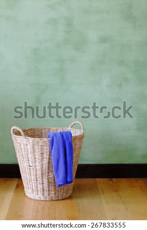 blue cloth in the woven basket in front of green cement wall