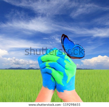 Blue Butterfly on hand, Map of world painted on hands in the blue sky.