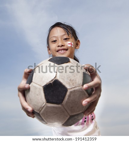 Young Girls Like Football with painted face and holding a ball
