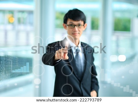 young business man in a suit pointing with his finger to touch screen interface .