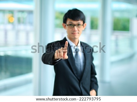 young business man in a suit pointing with his finger