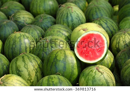 watermelon slice.Many big sweet green watermelons and one cut watermelon.