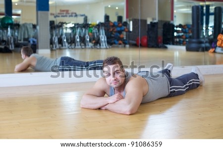 A young man working out at the gym takes time to rest a smile for the camera