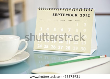 Desktop calendar sitting on a glass desk showing the month of September 2012
