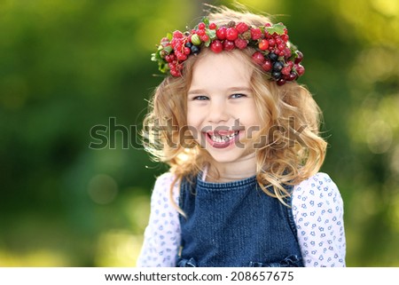portrait of a beautiful little girl with berries