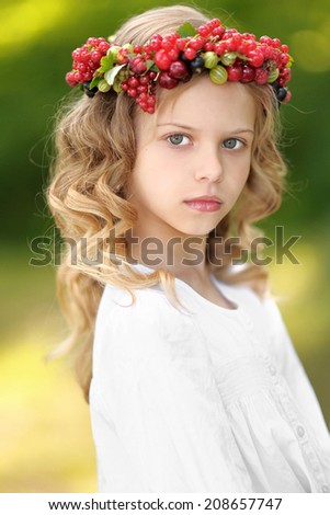 portrait of a beautiful little girl with berries